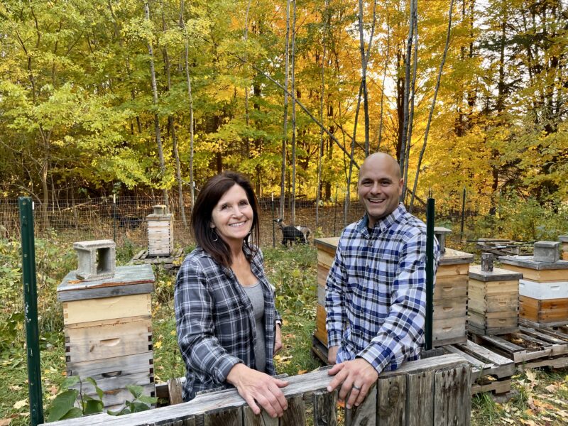 two people with flannels outside building with woof in northern michigan